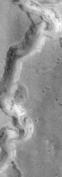 NASA's Mars Global Surveyor shows a transition zone between the cratered highlands of Arabia Terra, and the less-cratered lowlands of Acidalia Planitia on Mars. Boulders are present on some hill slopes, and plains between the hills are rough and pitted.