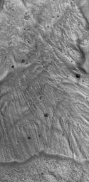 NASA's Mars Global Surveyor shows a portion of a large landslide deposit on the floor of western Tithonium Chasma on Mars.