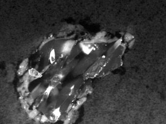 This image shows a comet particle collected by NASA's Stardust spacecraft. The particle is made up of the silicate mineral forsterite, also known as peridot in its gem form.