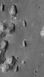 This image from NASA's Mars Global Surveyor shows layered buttes, knobs, and other landforms exposed by erosion in the Aeolis region of Mars.