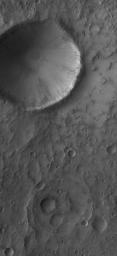 NASA's Mars Global Surveyor shows an impact crater located in Terra Sabaea on Mars. South of the impact crater is a second, more subdued circular feature which is probably an ancient impact crater that was buried and only partially exhumed.