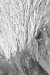 NASA's Mars Global Surveyor shows a circular feature, a partly-exhumed vrater, interpreted to be an ancient impact crater on Mars that formed on the same layered rock surface into a channel.