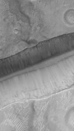 NASA's Mars Global Surveyor shows a portion of a trough in the Sirenum Fossae region on Mars. On the floor and walls of the trough, large, truck- to house-sized, boulders are observed at rest.