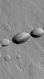 NASA's Mars Global Surveyor shows a chain of collapse pits on the lower south flank of Ascraeus Mons on Mars. Pit chains such as this are the result of collapse along fault lines. 