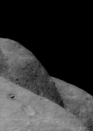 This image of asteroid Eros, taken by NASA's NEAR Shoemaker on Dec. 9, 2000, shows curvatures in the foreground and background along the eastern and western edges of the saddle.