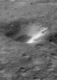 This image of asteroid Eros, taken by NASA's NEAR Shoemaker on Jan. 11, 2001, shows material on the inner wall of a crater, brighter than the surrounding regolith and is thought to be subsurface material exposed when overlying, darker regolith slides off.