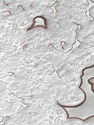 NASA's Mars Global Surveyor shows a landscape of Mars' south polar residual cap dominated by layered, frozen carbon dioxide ('dry ice') that has been eroded into a variety of pits, troughs, buttes, and mesas.