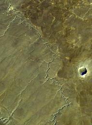 This view acquired by NASA's Landsat 4 satellite on December 14, 1982, shows Barringer Crater, also known as 'Meteor Crater,' a deep hole in the flat-lying desert sandstones west of Winslow, Arizona.