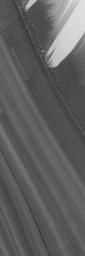 This image from NASA's Mars Global Surveyor shows a slope on which layered materials are exposed by erosion in the north polar region of Mars. Wind streaks are also evident in this summertime scene.