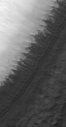 NASA's Mars Global Surveyor shows a mid-summer scene in Mars' south polar region. The light-toned surface is covered with seasonal frost.