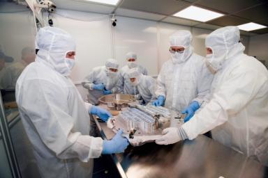 Investigators from University of Washington, Johnson Space Center, and Lockheed Martin Missiles and Space, Denver, Colorado, inspect a canister and sample collector soon after opening a container with Stardust material in a laboratory at the JSC.