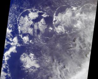 The image was acquired by NASA's Terra satellite on March 11, 2002, and is centered west of the Marshall Islands. Enewetak Atoll is discernible through thin cloud as the turquoise band near the right-hand edge of the image.