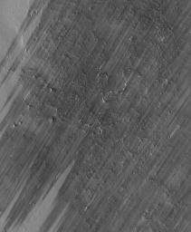 NASA's Mars Global Surveyor shows a wind-streaked plain in Tharsis near the Pavonis Mons volcano on Mars. The lighter-toned surfaces show how the plain used to look, before strong winds removed much of a thin coating of dust.