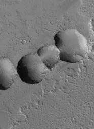 NASA's Mars Global Surveyor shows a chain of collapse pits fomed among dust-mantled lava flows in the eastern Tharsis region of Mars.
