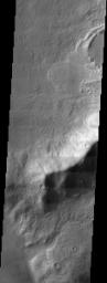 The channels and impact crater rim shown in this NASA Mars Odyssey image provide insight to the forces that have sculpted the surface within the extensive Reull Vallis network.
