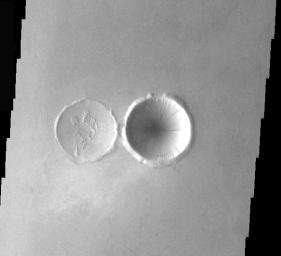 This image from NASA's Mars Odyssey shows two types of crater interiors found on Mars, original and modified. The crater on the right has its original bowl shape. The crater of the left has had its interior modified by an infilling of lava.
