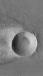 NASA's Mars Global Surveyor shows an impact crater in western Daedalia Planum on Mars, with a wind streak around it.