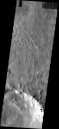 The slumping of materials in the walls of this impact crater imaged by NASA's Mars Odyssey spacecraft illustrates the continued erosion of the Martian surface. Small fans of debris as well as larger landslides are observed throughout the image.