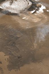 NASA's Mars Global Surveyor shows a north polar dust storm on March 7, 2003. White features at the top of the image are the water ice surfaces of Mar's north polar residual cap.