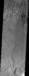 Embayment relationship is displayed where mottled plains material laps up against higher standing plains material in this image from NASA's Mars Odyssey spacecraft. The embaying material could be lava or possibly mud.