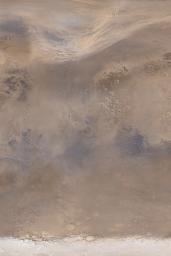 NASA's Mars Global Surveyor shows an early autumn dust storm sweeping east-northeast across the northern plains of Acidalia Planitia on Mars.