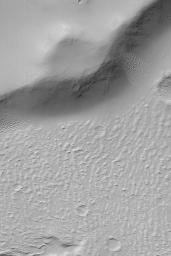 NASA's Mars Global Surveyor shows the margin of a lava flow near the edge of a scarp in far western Daedalia Planum on Mars. A blanket of dust covers the upland and the rugged lava flow surfaces.