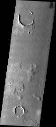 This image taken by NASA's 2001 Mars Odyssey shows craters and hills form high standing streamlined plateaus or islands in a channeled area on the martian landscape.