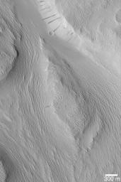 NASA's Mars Global Surveyor shows the wind-eroded surfaces of the Labou Vallis system on Mars. The original valley walls and floor were covered with a material that was later eroded by wind to form the sharp, rough textured terrain present here. 