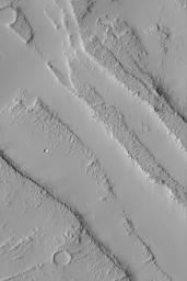 This image from NASA's Mars Global Surveyor shows dust-mantled troughs formed by faulting on plains near volcano, Ascraeus Mons. Smooth areas are covered with thick accumulations of dust, rougher surfaces are lava flows that have been blanketed by dust.