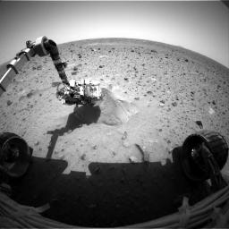 This image shows NASA's Mars Exploration Rover Spirit probing its first target rock, Adirondack. At the time this picture was snapped, the rover had begun analyzing the rock with the alpha particle X-ray spectrometer located on its robotic arm.