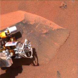NASA's Mars Exploration Rover Spirit shows its 'hand,' or the tip of the instrument deployment device, poised in front of the rock nicknamed Adirondack. A stainless steel brush located on its rock abrasion tool is seen here at the end of the yellow arrow.