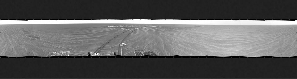 This image is a 360-degree view from NASA's Mars Exploration Rover Opportunity's position outside the small crater 'Eagle Crater.' Plentiful ripples are seen on the plains and two depressions featuring bright spots.