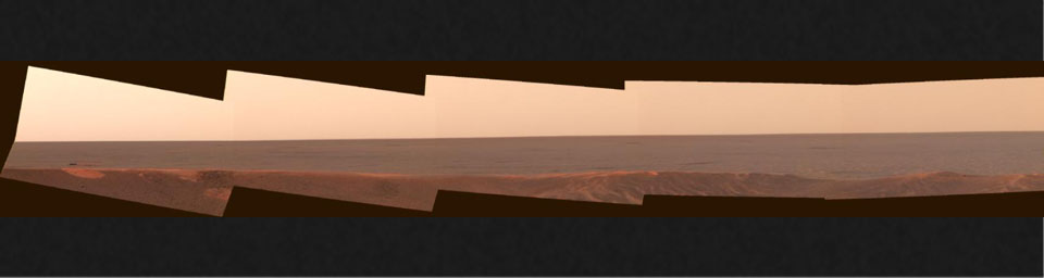 This mosaic of images from NASA's Mars Exploration Rover Opportunity looks to the southeast from inside Eagle Crater. This was among the first peeks out into the plains, revealing the enigmatic dark feature dubbed 'Bounce' rock.