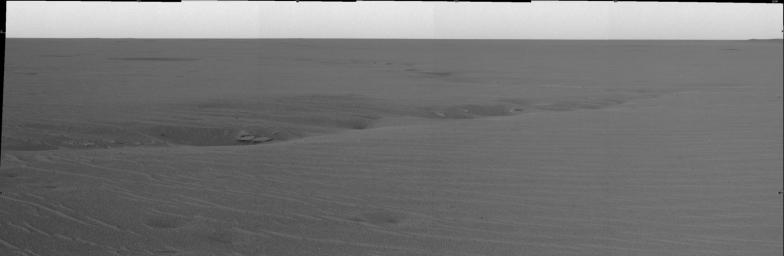 This image, acquired by the panoramic camera on NASA's Mars Exploration Rover Opportunity, highlights the vast plains of Meridiani Planum focusing on a sinous crack consisting of a series of deep dimples sprinkled with rocks.
