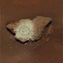 This false-color composite of the rock dubbed 'Bounce' shows the rock after NASA's Mars Exploration Rover Opportunity drilled into it with its rock abrasion tool. The drilling of the hole generated a bright powder.