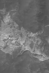 NASA's Mars Global Surveyor shows light-toned, somewhat layered rock outcrops on the north wall of Columbus Crater on Mars. Remnants are found all around the walls of the crater, and at least one small remnant has been spotted on the crater floor.
