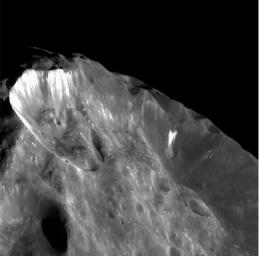 This image from NASA's Cassini spacecraft shows bright wispy streaks thought to be ice revealed by subsidence of crater walls.