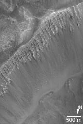 NASA's Mars Global Surveyor shows a fantastic outcrop of alternating light and dark layers in the wall of a crater that impacted into the floor of one of the eastern Kasei Valles flood channels on Mars.