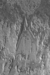 NASA's Mars Global Surveyor shows eroded layer outcrops in a crater in Terra Tyrrhena on Mars where exposures of layered, sedimentary rock are common.