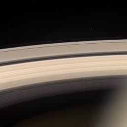 Saturn and its rings are prominently shown in this color image, along with three of Saturn's smaller moons. This image was taken on June 18, 2004, with NASA's Cassini spacecraft's narrow angle camera, 8.2 million kilometers from Saturn.