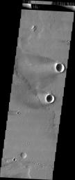 This image released on July 13, 2004 from NASA's 2001 Mars Odyssey shows windstreaks are features caused by the interaction of wind and topographic landforms on Mars such as two large windstreaks of the scour-and-deposit type.