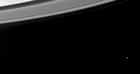 This image from NASA's Cassini spacecraft shows a nearly half-full Mimas (a moon that is 398 kilometers, or 247 miles, across) beyond Saturn's rings.