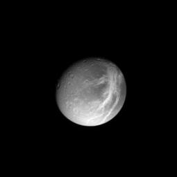 A gorgeous Dione poses for NASA's Cassini spacecraft, with shadowed craters and bright wispy streaks first observed by the Voyager spacecraft 24 years ago.