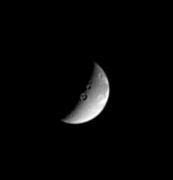 This image captured by NASA's Cassini spacecraft shows three sizeable impact craters, including one with a marked central peak, lie along the line that divides day and night on the Saturnian moon, Dione.