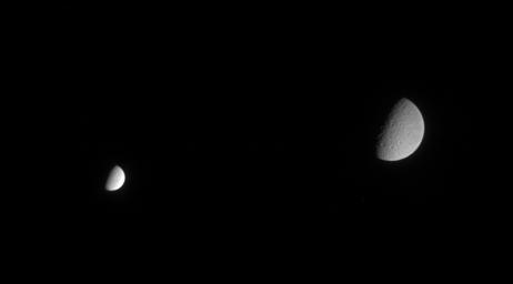 Though farther away from Cassini when the spacecraft acquired this image, Saturn's second-largest moon Rhea still dwarfs the brightest icy moon Enceladus in this scene. Image was taken in visible light with NASA's Cassini spacecraft's narrow-angle camera.