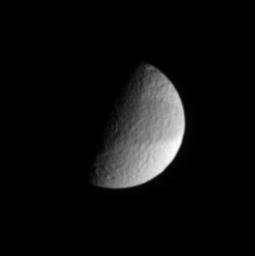 In this infrared view from NASA's Cassini spacecraft, Saturn's cratered moon Tethys shows a faint, dark band across its equatorial region.