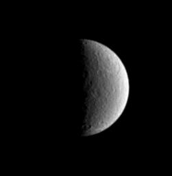 The large Tirawa impact basin on Saturn's moon Rhea is visible at the two o'clock position in this image captured by NASA's Cassini spacecraft.