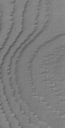 NASA's Mars Global Surveyor shows layers broken-up by processes that form nearly square polygonal cracks and textures in the south polar region of Mars.