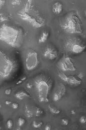 NASA's Mars Global Surveyor shows mesas and buttes on the floor of a depression in the Labyrinthus Noctis region of Mars. This is part of the western Valles Marineris.