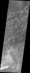 This image released on Sept 21, 2004 from NASA's 2001 Mars Odyssey shows Candor Chasma's northern rim on Mars. Just below the canyon wall is debris material that once formed part of the canyon wall.
